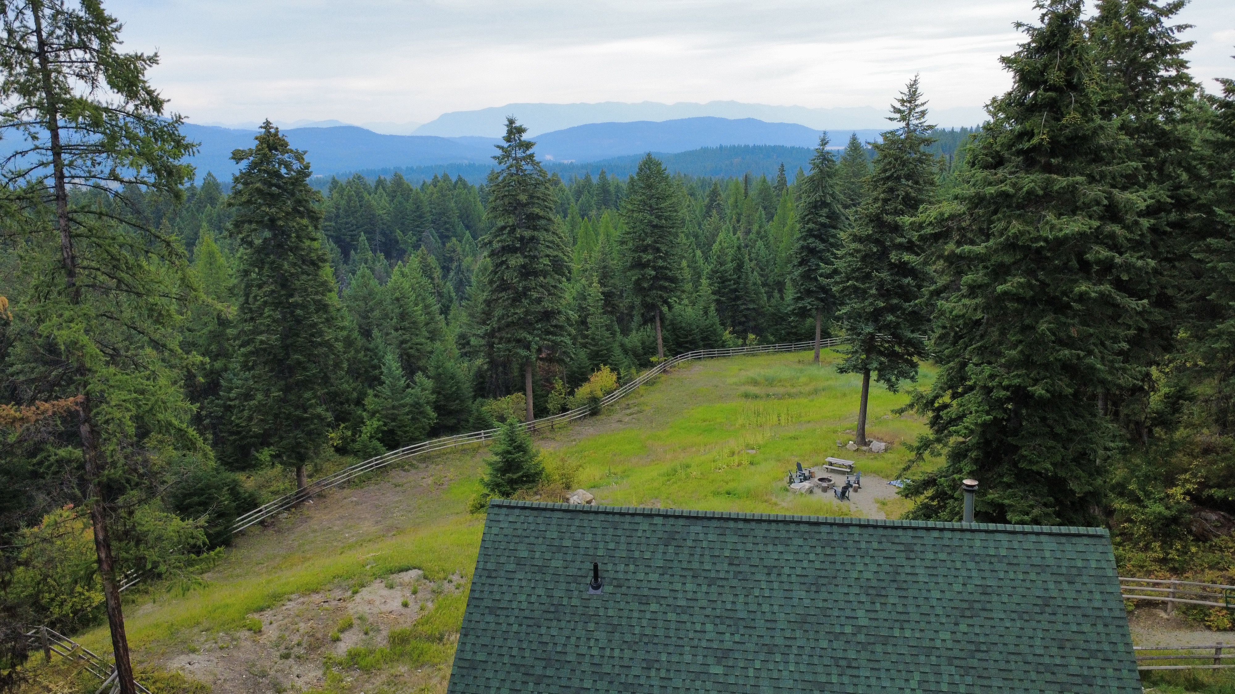 Aerial view over the cabin and surrounding forest canopy