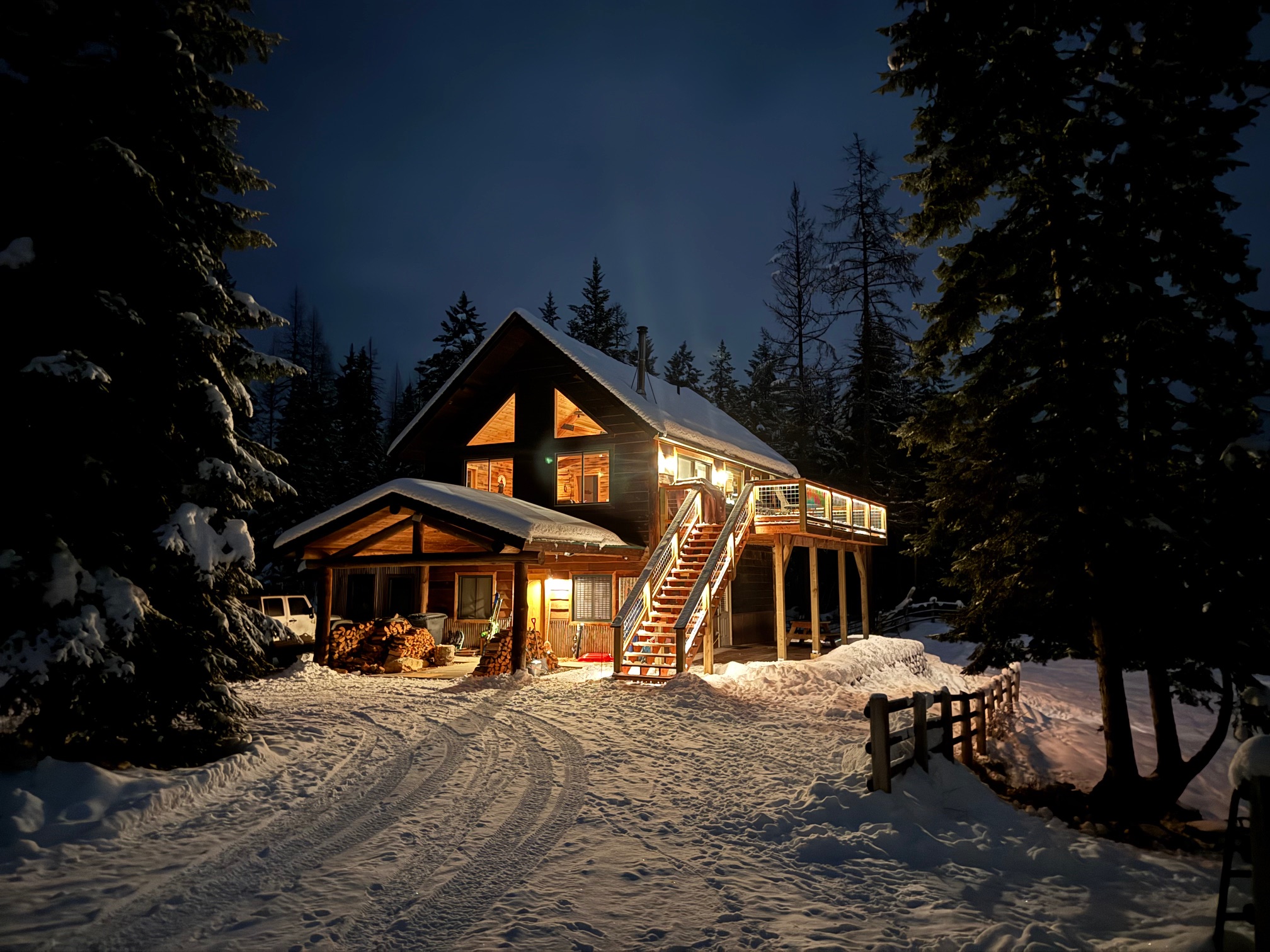 Moonlight Ridge cabin glowing at night surrounded by snow-covered pines